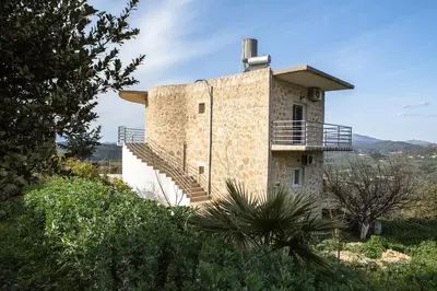 a building with a staircase on the side of it at Rokka Pyrgos Amazing View - Maistros in Rókka