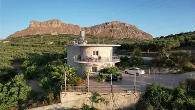 a house on a hill with a mountain in the background at Rokka Pyrgos Amazing View - Maistros in Rókka
