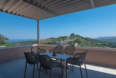 a table and chairs on a balcony with a view at Alexandras's Mansion - Alexinia's House in Ayiá