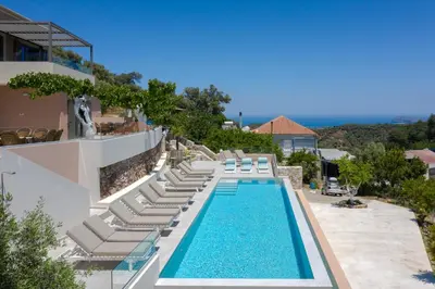 a pool with chaise lounge chairs and a resort at Alexandras's Mansion - Alexinia's House in Ayiá