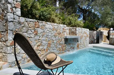 a hat sitting in a chair next to a swimming pool at Alexandras's Mansion - Fragkia's House in Ayiá