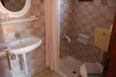 a small bathroom with a sink and a toilet at Hotel Stavris in Khóra Sfakíon