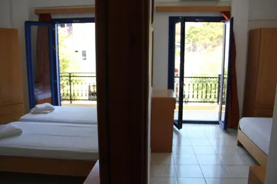 a view of a room with two beds and a balcony at Hotel Stavris in Khóra Sfakíon