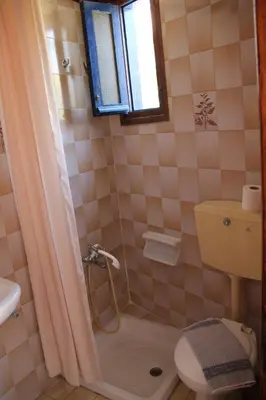 a bathroom with a shower and a toilet and a sink at Hotel Stavris in Khóra Sfakíon