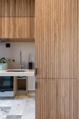 a kitchen with a sink and a wooden wall at Domi Luxury Apartment by Cura Villas Collection in Chania Town