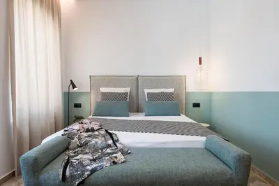 a bedroom with a large bed with a blue couch at Domi Luxury Apartment by Cura Villas Collection in Chania Town