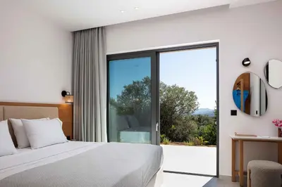 a bedroom with a bed and a sliding glass door at Villa Aglaea I Saltwater Pool & Amazing Seaview! in Chania Town