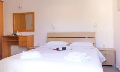 a bedroom with a white bed with towels on it at Anchris Paleochora in Palaiochóra