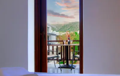 a room with a view of a balcony with a table at Anchris Paleochora in Palaiochóra