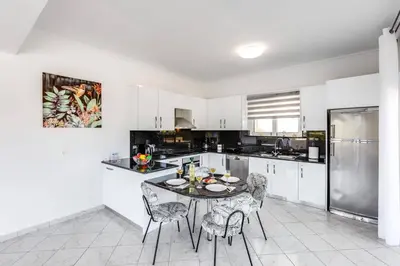 a kitchen with a table and chairs and a refrigerator at Villa Athena by Villa Plus in Almirida