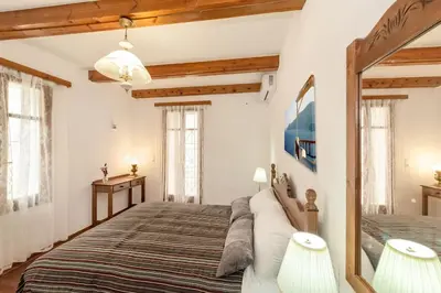 a bedroom with a large bed and two windows at Yiayia's Place in Chania in Chania Town