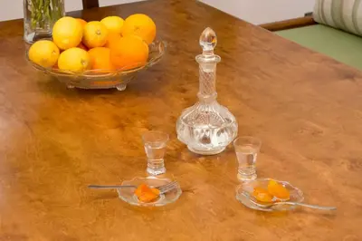 a table with a bowl of oranges and a glass bottle at Traditional house in Fres in Karés