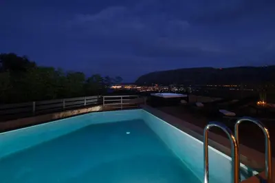 a swimming pool on top of a building at night at Thearia villa I - seaview , private heated pool & jacuzzi in Souda