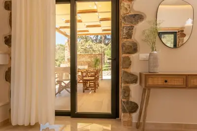 a door leading into a dining room with a table at Aoria Villas in Palaiochóra
