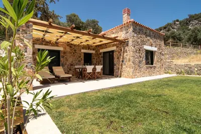 an external view of a stone house with a patio at Aoria Villas in Palaiochóra