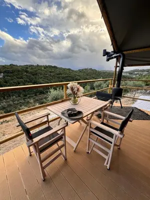 a wooden deck with a table and two chairs at Civara Chalet - Private Glamping in nature with Jacuzzi in Tsivarás