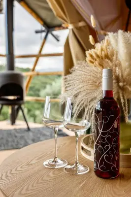 a bottle of wine and two glasses on a table at Civara Chalet - Private Glamping in nature with Jacuzzi in Tsivarás