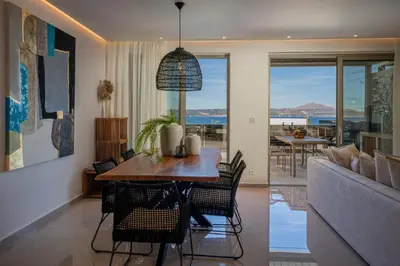 a dining room with a table and chairs and a couch at AmphiMatrion Luxury Residence in Kalyves