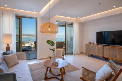 a living room with a couch and a tv at AmphiMatrion Luxury Residence in Kalyves