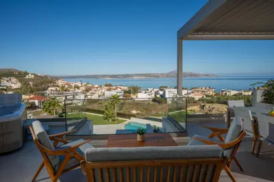 a view from the balcony of a house with a table and chairs at AmphiMatrion Luxury Residence in Kalyves