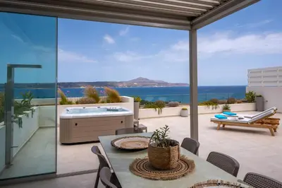 a patio with a table and a tub on a balcony at AmphiMatrion Luxury Residence in Kalyves