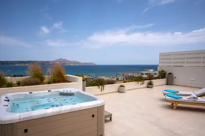 a hot tub on a patio with a view of the ocean at AmphiMatrion Luxury Residence in Kalyves