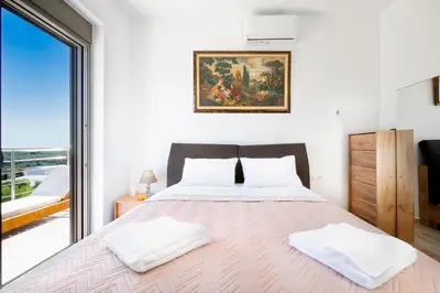 a bedroom with a bed and a large window at Villa Idyllic in Maleme