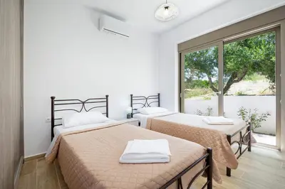 two beds in a room with a window at Villa Idyllic in Maleme