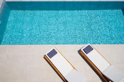 two lounge chairs next to a swimming pool at Etheria Villa in Chania Town