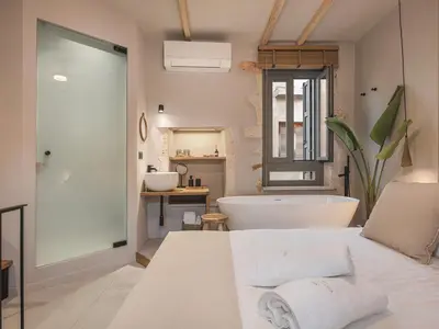a bathroom with a bath tub and a bed at Casa Athanasia in Chania Town