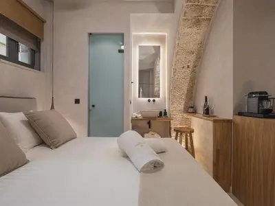 a bedroom with a white bed and a mirror at Casa Athanasia in Chania Town