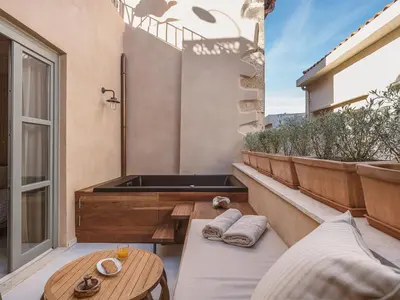 a balcony with a bath tub and a table at Casa Athanasia in Chania Town