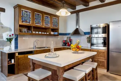 a kitchen with a large island with white counter tops at Villa Kois by PosarelliVillas in Tzitzifés