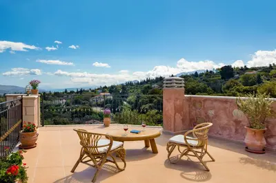 a patio with a table and chairs and a view at Villa Kois by PosarelliVillas in Tzitzifés