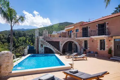 a villa with a swimming pool in front of a house at Villa Kois by PosarelliVillas in Tzitzifés