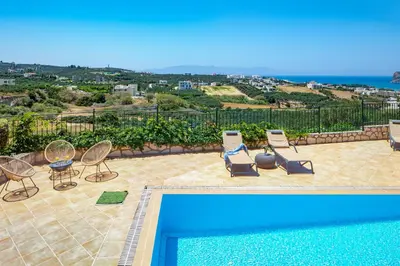 a patio with chairs and a swimming pool at Pasiphae villas 1 & 2 in Stalos