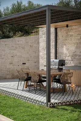 a patio with a wooden table and chairs under a pavilion at Melanthia Villas in Tsivarás