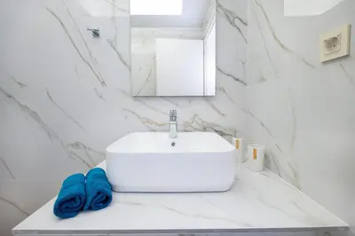 a bathroom with a white sink and a blue towel at Villa Avo in Chania Town