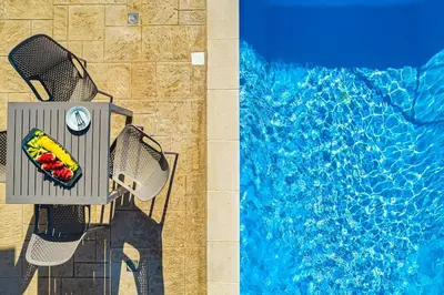 a pool with a chair with a fruit basket next to it at Apartment Lia with private eco pool - Amazing view in Chania Town