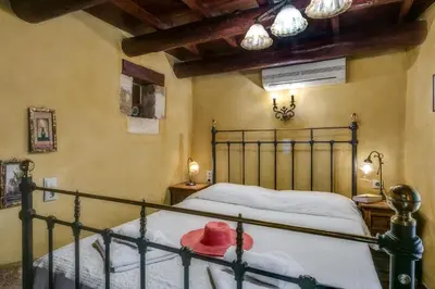 a bedroom with a bed with a metal bed frame at IFIGENIA TRAD.ROOMS IN OLDTOWN BY.MARIOS in Chania Town