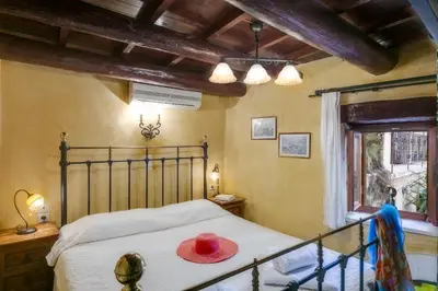 a bedroom with a bed with a red hat on it at IFIGENIA TRAD.ROOMS IN OLDTOWN BY.MARIOS in Chania Town