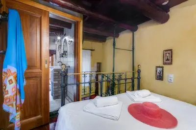 a bedroom with a bed with two hats on it at IFIGENIA TRAD.ROOMS IN OLDTOWN BY.MARIOS in Chania Town