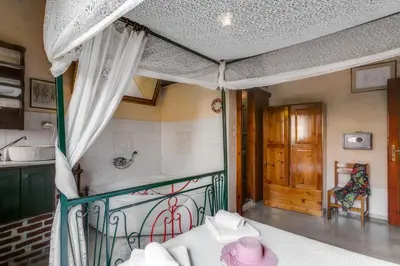 a bedroom with a bed with a canopy and a door at IFIGENIA TRAD.ROOMS IN OLDTOWN BY.MARIOS in Chania Town