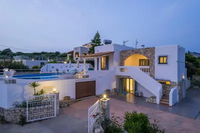 a villa with a swimming pool at dusk at Seaview Villa Prima, Sea & Sun Villas in Chorafakia