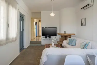 a living room with two white couches and a tv at Seaview Villa Prima, Sea & Sun Villas in Chorafakia