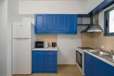 a kitchen with blue cabinets and a white refrigerator at Seaview Villa Prima, Sea & Sun Villas in Chorafakia