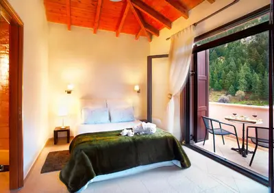 a bedroom with a bed and a large window at Villa Zourva in Zoúrva
