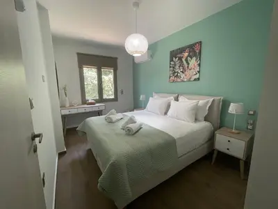 a bedroom with a large white bed and a window at Aryiro's Residence,Cozy&Sunny in Alikianós