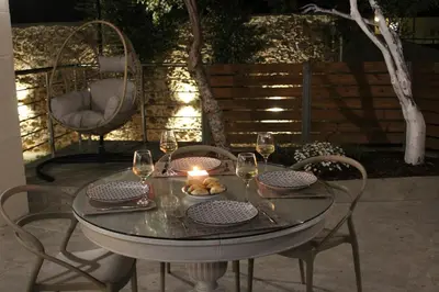 a table with wine glasses and a candle on a patio at Aryiro's Residence,Cozy&Sunny in Alikianós