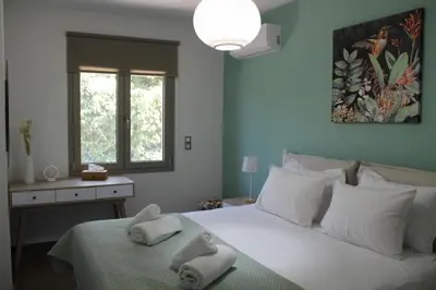 a bedroom with a large white bed with towels on it at Aryiro's Residence,Cozy&Sunny in Alikianós